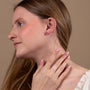 Garnet Cross Stud Earrings in 925 Sterling Silver – shown worn